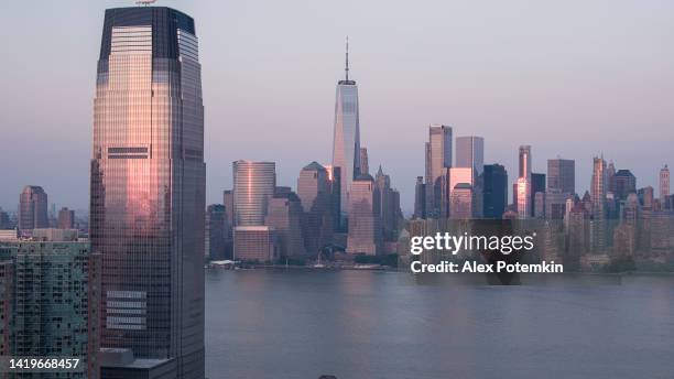 lower manhattan with famous freedom tower from the hudson river and jersey city with modern skyscraper. - jersey city stock pictures, royalty-free photos & images
