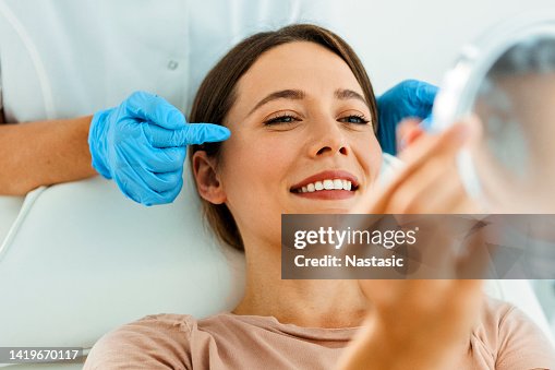 Beautiful Woman on Facial Treatment looking at mirror Beautiful Woman on Facial Treatment looking at mirror