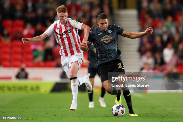 Nathan Wood of Swansea City is tackled by Sam Clucas of Stoke City during the Sky Bet Championship between Stoke City and Swansea City at Bet365...