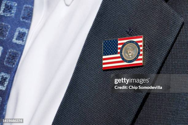 Former Trump White House Advisor Peter Navarro wears a lapel pen with the presidential seal while talking with reporters folllowing a motion hearing...