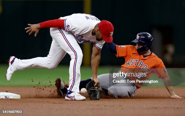 Marcus Semien of the Texas Rangers fields a single hit by Alex Bregman of the Houston Astros as Jose Altuve of the Houston Astros slides into second...