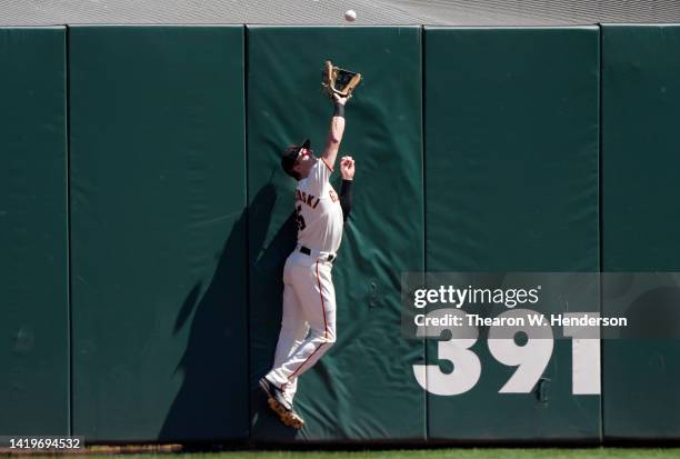 Mike Yastrzemski of the San Francisco Giants makes a leaping catch at the wall taking a hit away from Brandon Drury of the San Diego Padres in the...