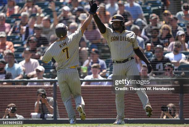 Ha-Seong Kim of the San Diego Padres is congratulated by Josh Bell after Kim scored against the San Francisco Giants in the top of the fourth inning...