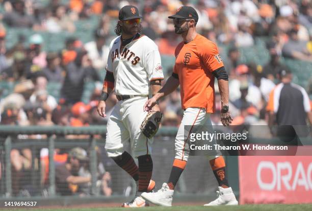 Brandon Crawford of the San Francisco Giants walks off the field with manager Gabe Kapler after Crawford was ejected from the game for arguing strike...