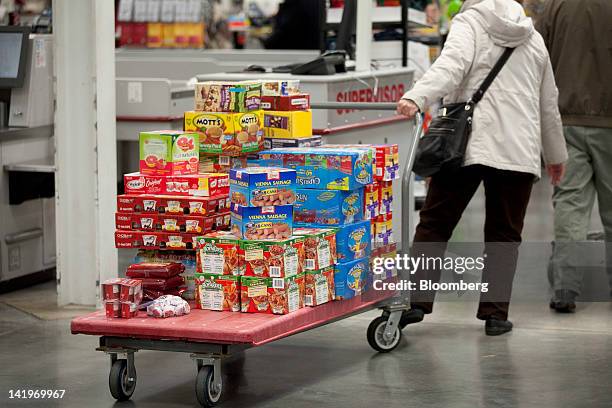 Customer pulls a cart of groceries through a BJ's Wholesale Club Inc. Store in Falls Church, Virginia, U.S., on Tuesday, March 27, 2012. The U.S....