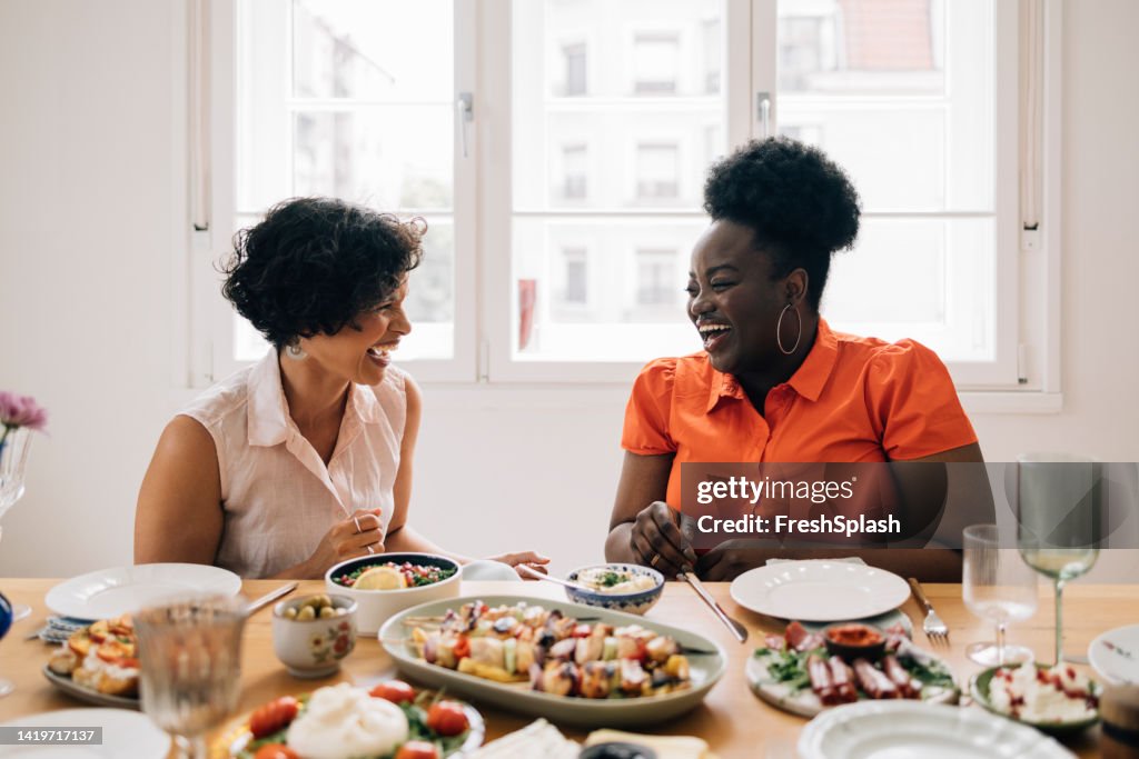 Happy Diverse Friends Sitting At The Table And Talking To Each Other