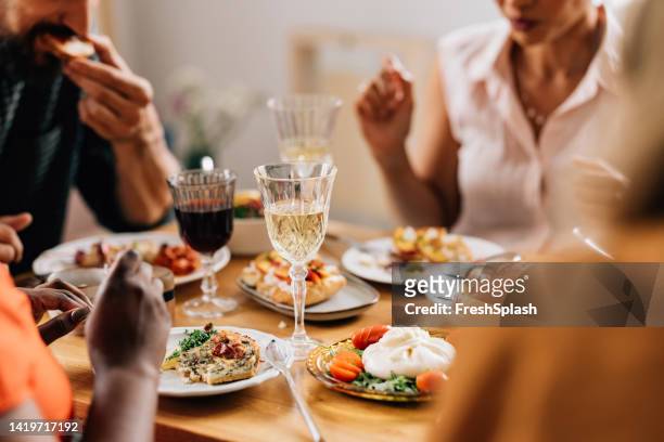 unkenntlich verschiedenste freunde, die wein trinken, während sie zusammen zu mittag essen - dinner party menschen raum elegant stock-fotos und bilder