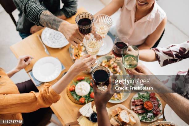 a group of unrecognizable happy diverse friends celebrating some achievement - champagne flute high angle stock pictures, royalty-free photos & images