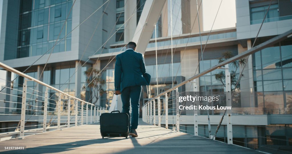 Viagem, hotel e empresário caminhando com sua bagagem em direção ao aeroporto ou edifício de escritórios na cidade. Empresário masculino vai em viagem de negócios e chega ao destino para nova oportunidade de carreira