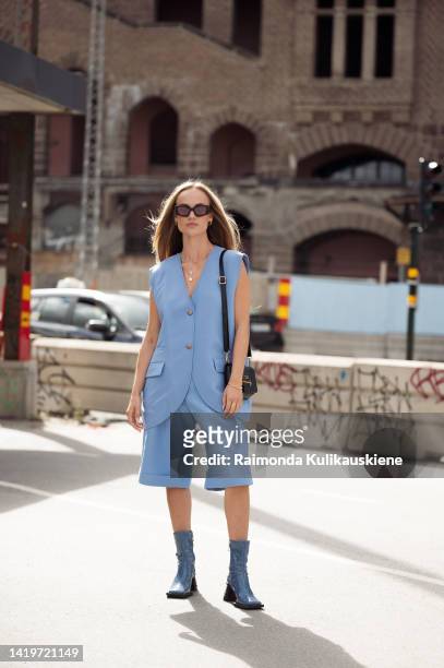 Amanda Winberg wearing light blue Bermuda shorts, matching blue vest, blue ankle shoes and black Prada bag outside Swedish School of Textil show in...