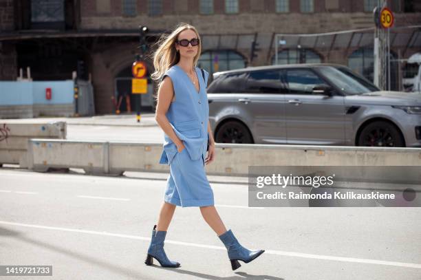 Amanda Winberg wearing light blue Bermuda shorts, matching blue vest, blue ankle shoes and black Prada bag outside Swedish School of Textil show in...