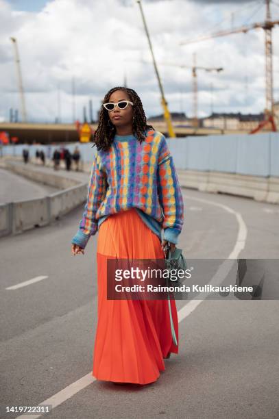 Elizabeth Delphine wearing bright neon long pleased skirt, colourful matching sweater and mint green mini bag outside Swedish School of Textil show...