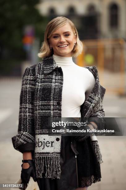 Alicia Agneson wearing Swedish Stockings white and purple checkered tights, short black skirt, white turtle neck top, black and white checkered...