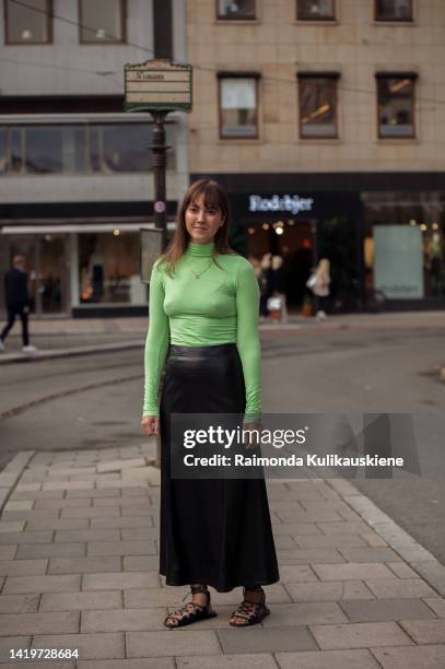 Aguest wearing apple green turtle neck top, long black leather skirt and sandals outside Rodebjer show in Stockholm fashion week Spring / Summer 2023...