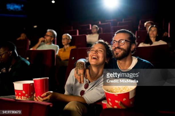 young couple enjoying a fun movie at the cinema - filmindustrie stockfoto's en -beelden