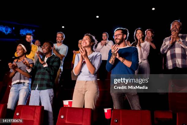 satisfied audience applauding at the end of a movie at the cinema - film festival stockfoto's en -beelden