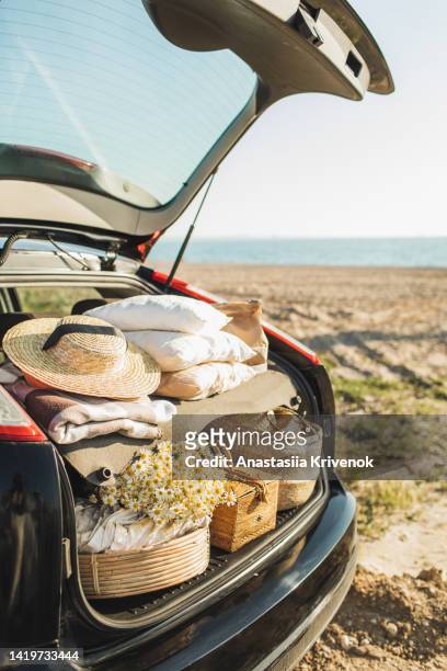 picnic things in trunk of car ready to depart for weekend. - bagageiro parte de veículo - fotografias e filmes do acervo