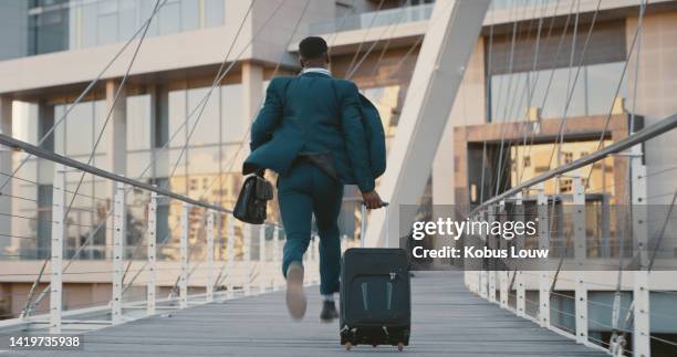 businessman running late, to an airport terminal with luggage or walking to get on a plane for a business deal. young male with ticket rushing to a flight for travel, vacation or journey by airplane. - travel destinations running stock pictures, royalty-free photos & images