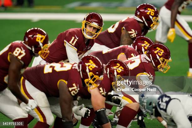 Alex Smith of the Washington Football Team looks down the line of scrimmage during an NFL game against the Dallas Cowboys at AT&T Stadium on November...