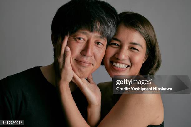 portrait of asian transnational couple - couple sourire studio photos et images de collection