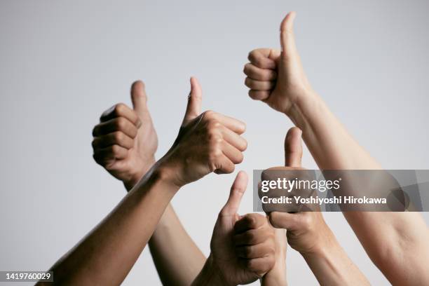 asians of other ethnic groups giving the thumbs up - tummen upp bildbanksfoton och bilder