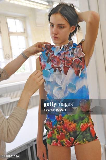 Preview shot of an assistant at Maison Martin Margiela fitting a model with graphic, 3D inspired top in preparation for Martin Margiela's Spring 2010...