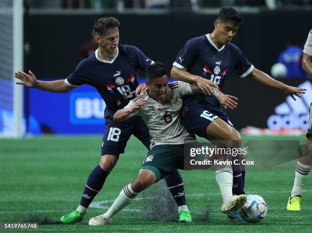 Erik Sanchez of Mexico attacks the ball against Matias Galarza and Lorenzo Melgarejo of Paraguay during the second half of an international friendly...