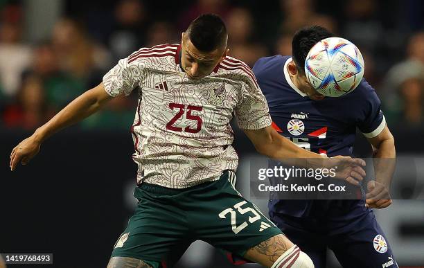 Saul Salcedo of Paraguay wins a header against Roberto Alvarado of Mexico during the first half of an international friendly between Mexico and...