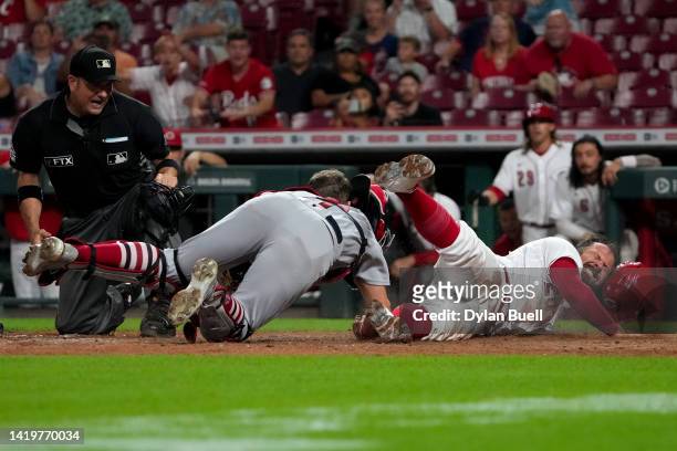 Andrew Knizner of the St. Louis Cardinals tags out Austin Romine of the Cincinnati Reds at home plate in the 12th inning at Great American Ball Park...