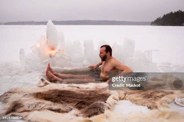 mature man enjoying ice bath at frozen lake - 中年の男性一人 ストックフォトと画像