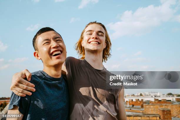 cheerful young male friends with sweat stains on t-shirts - free hugs photos et images de collection