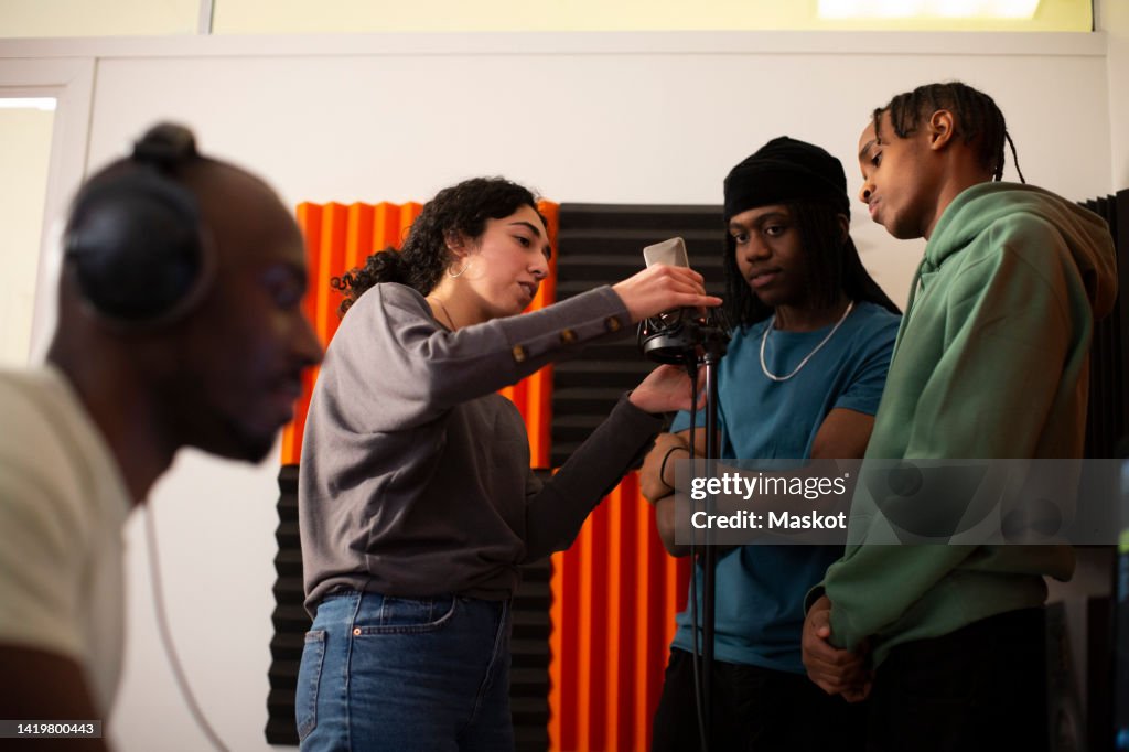 Revus Rapper Standing Woman Adjusting Microphone While Rappers Standing In Studio High-Res ...