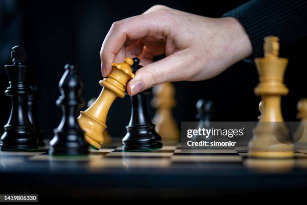 woman's hand playing chess - conflict of interest stock pictures, royalty-free photos & images