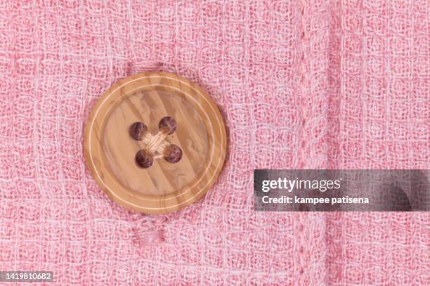button and texture of knitted white fabric. pink background. - sewing button stock pictures, royalty-free photos & images
