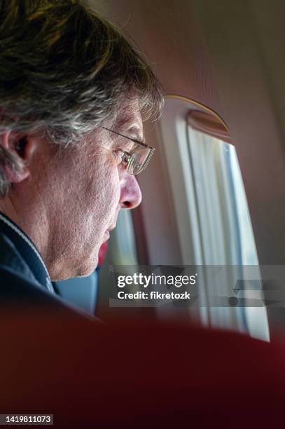 ein flugzeugpassagier beobachtet den himmel durch das fenster. - first class plane stock-fotos und bilder