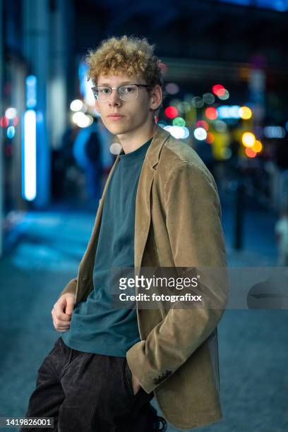 serious young man in front of urban background - blond boy stockfoto's en -beelden
