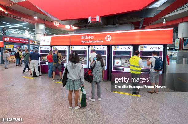 Several people buy their tickets at the automatic ticket booths at the Atocha train station, on September 1 in Madrid, Spain. Discounts on public...