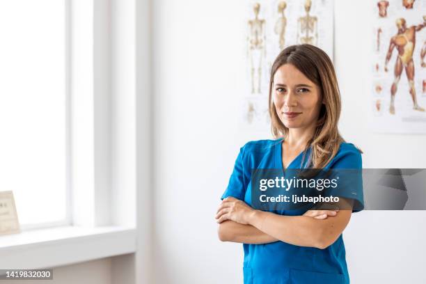 portrait of female nurse wearing scrubs in hospital - assistans stock pictures, royalty-free photos & images