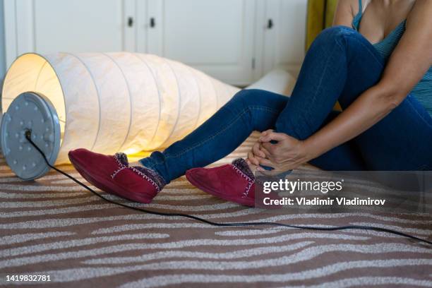 a woman sitting on ground after stumbling with an electrical cord - tripped-over stock pictures, royalty-free photos & images