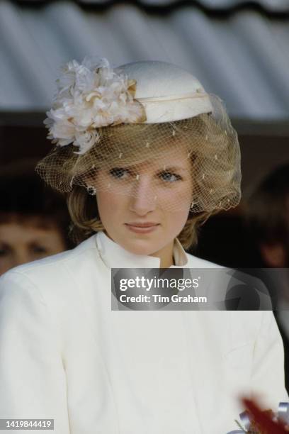 Princess Diana in a white outfit by Catherine Walker with veiled hat in Tauranga, New Zealand, April 1983.