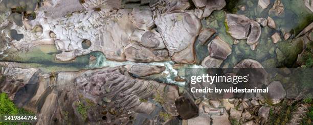 aerial view of the smoothly eroded granite boulders at the babinda boulders picnic ground. - queensland aerial stock pictures, royalty-free photos & images