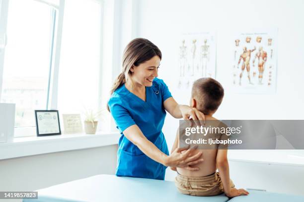 examining his spine to adjust therapy plan - backbone stock pictures, royalty-free photos & images