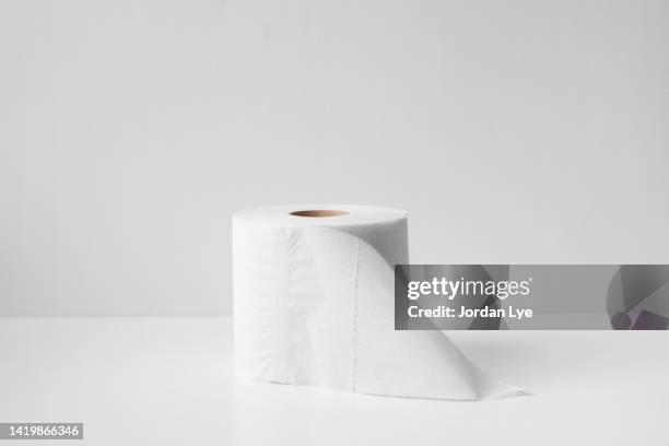 white toilet paper on white background - carta igienica foto e immagini stock