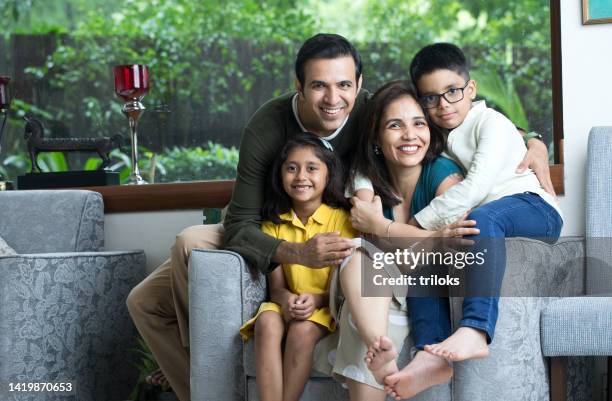 portrait of a family smiling - indian couple at home imagens e fotografias de stock