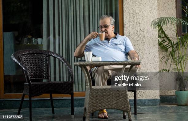 senior man having tea at home - senior man drinking tea stock pictures, royalty-free photos & images