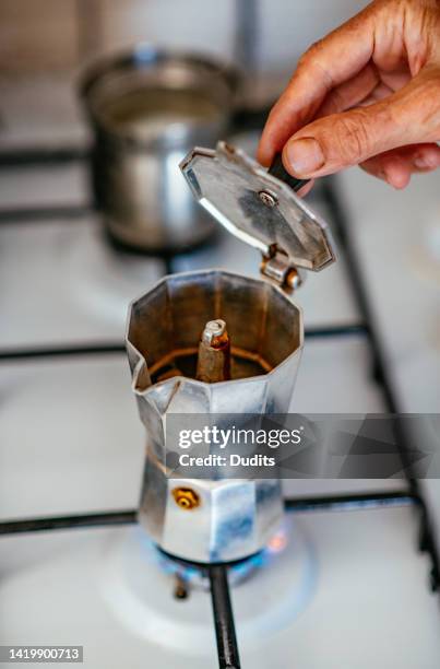 making coffee with the moka pot on the stove - moka pot stock pictures, royalty-free photos & images