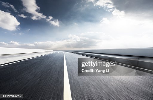 Low and wide angle view of asphalt road with blurred motion in shine day Low and wide angle view of asphalt road with blurred motion in shine day