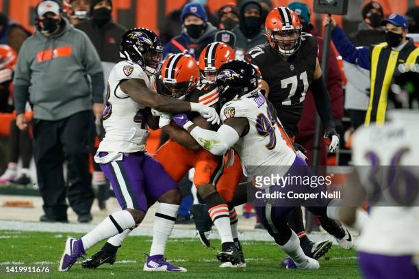 Morgan Cox of the Baltimore Ravens and linebacker Matthew Judon tackle Nick Chubb of the Cleveland Browns during an NFL game against the Cleveland...