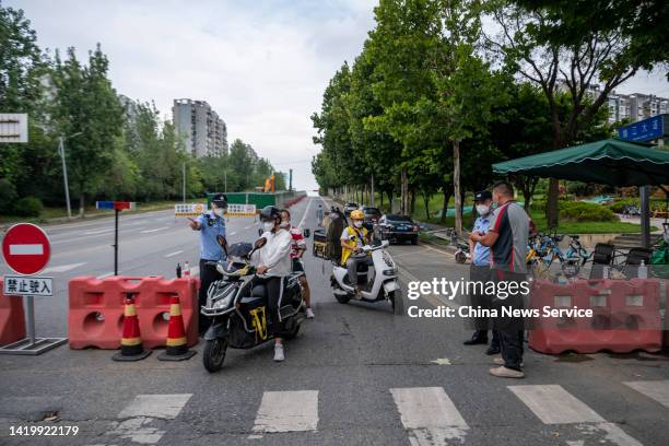 Police officers check health codes and negative nucleic acid test certificates of deliverymen as Chengdu imposes city-wide static control to curb new...