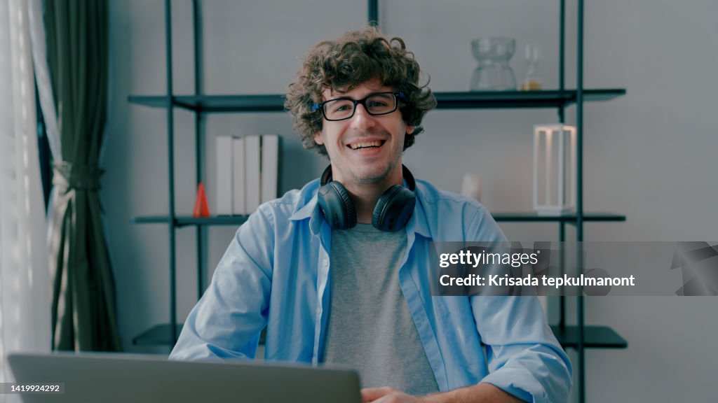 Young Adult Man Looking at Camera Happily after Giving Presentation via Video Conference.